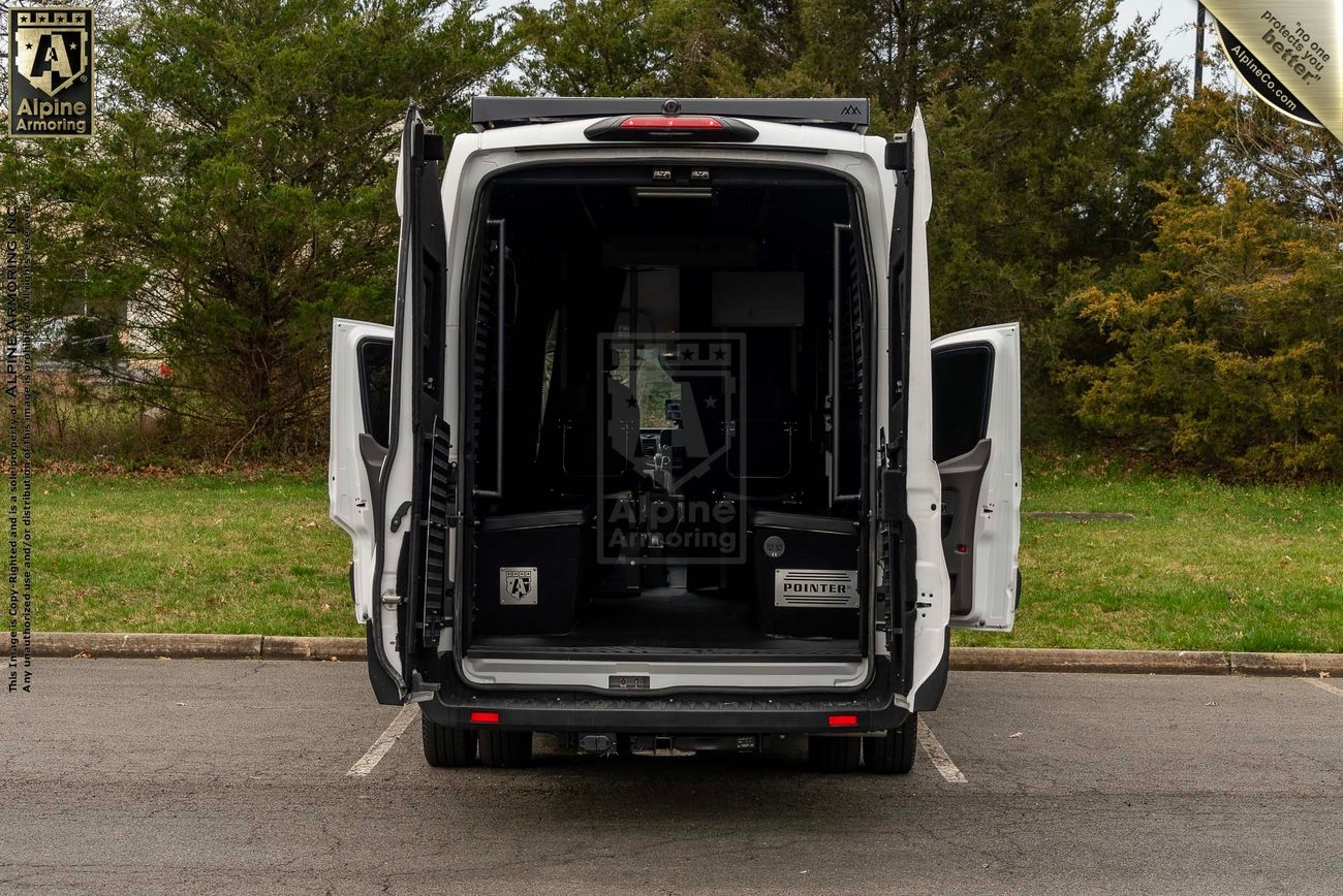 A white Pointer van with its back doors open, revealing an empty cargo space. The van is parked in a lot with greenery in the background.