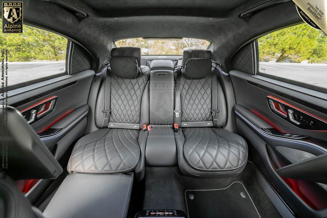 Rear seat interior of a black Mercedes-Benz S580 sedan featuring quilted leather upholstery, ample legroom, and high-end detailing.