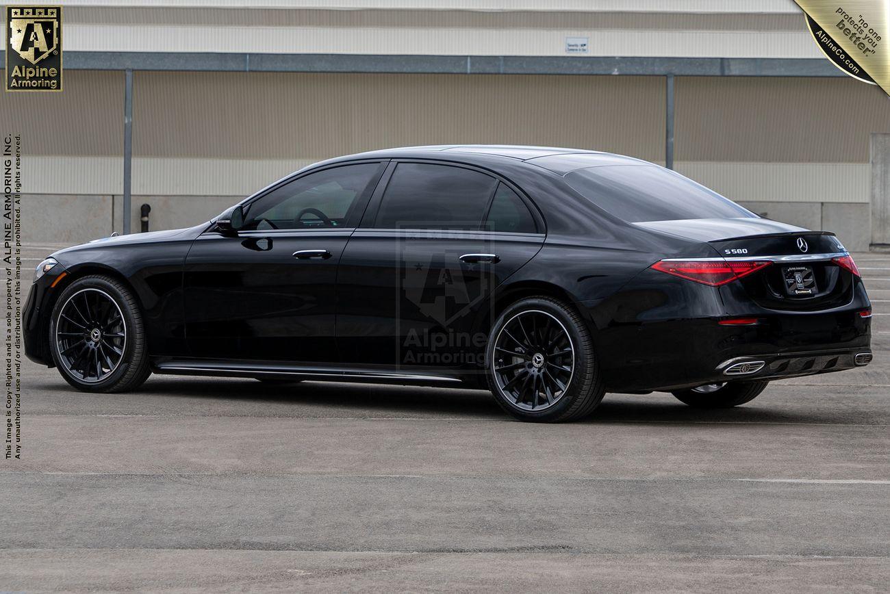 Black luxury Mercedes-Benz S580 sedan parked in a lot, viewed from the rear side. The vehicle features dark tinted windows and sleek design lines.