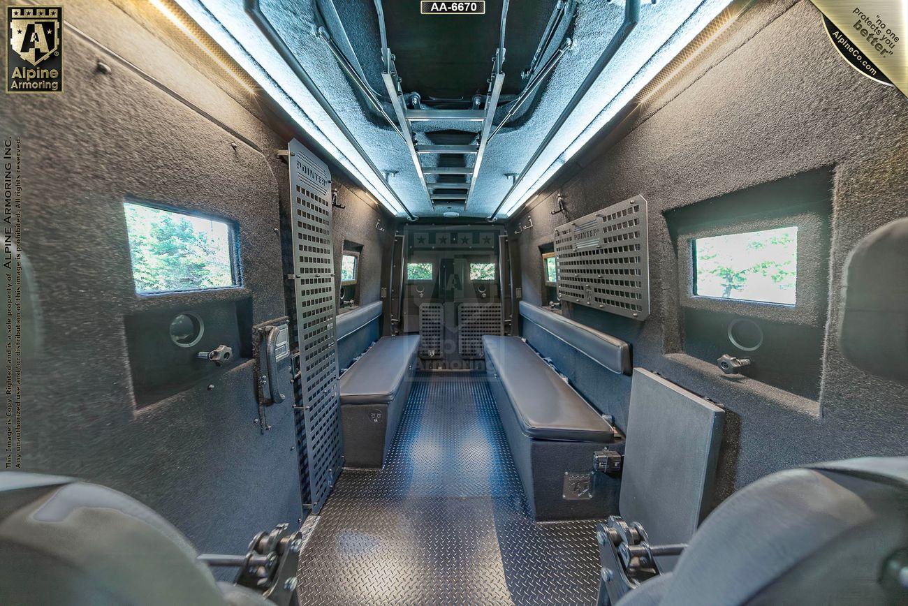 Interior of a SWAT Pointer Van from Alpine Armoring with secure seating, bench seats along the sides, and reinforced walls and windows.