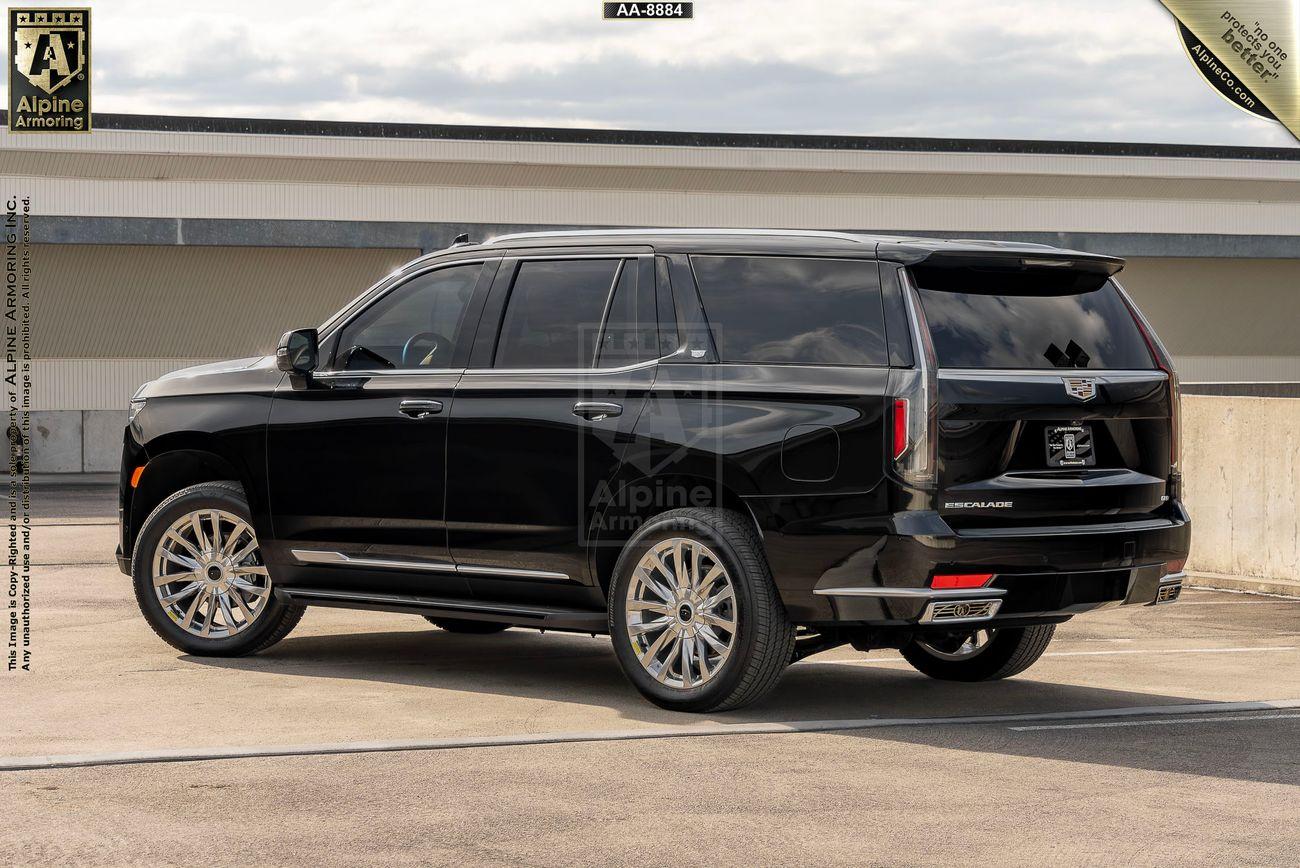 A black, armored Cadillac Escalade Premium Luxury SUV with tinted windows, parked in a rooftop parking lot on an overcast day. The vehicle's brand and model are visible on the rear.