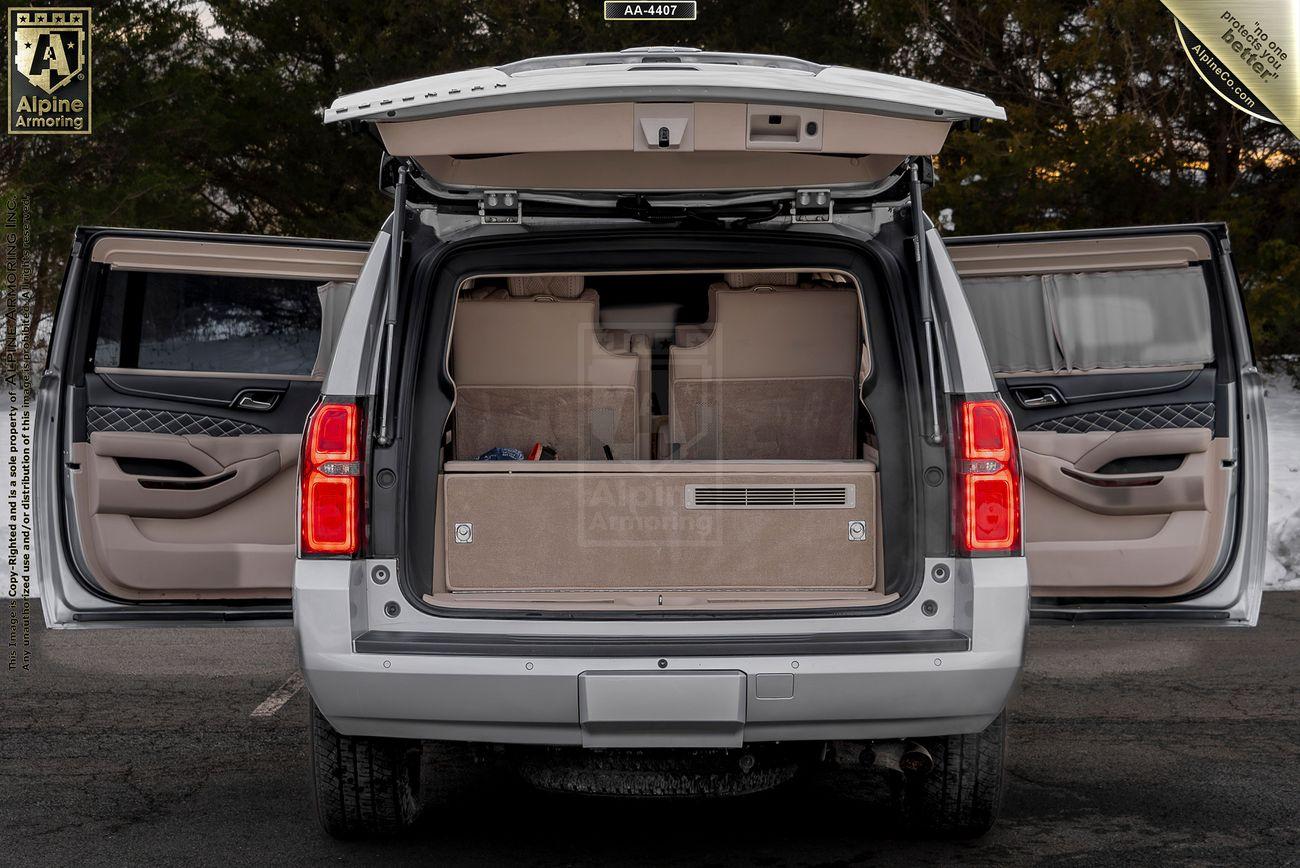 A white armored Chevrolet Suburban 3500HD LT VIP Limo with all doors open reveals a spacious, empty interior with beige lining.