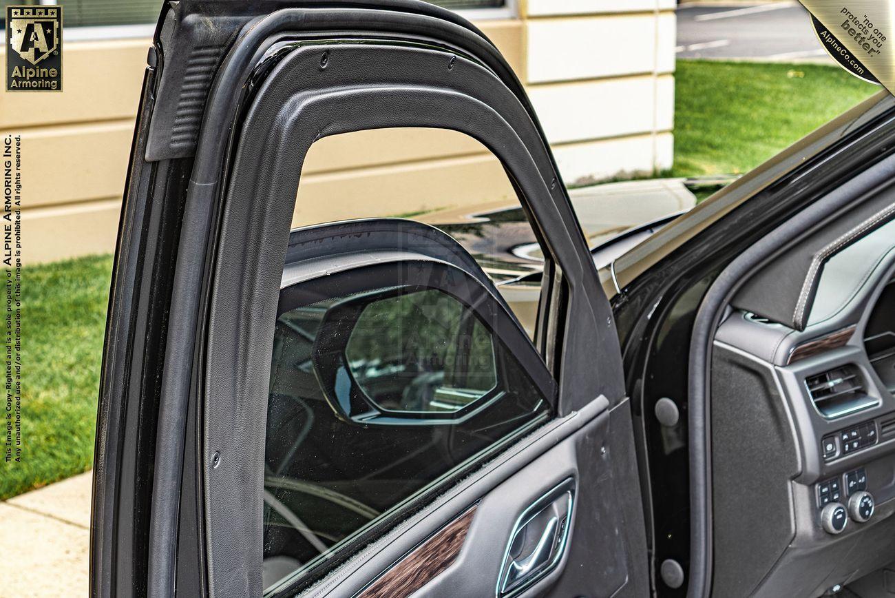 A close-up of an open Chevrolet Tahoe SUV door with customized weatherstrips around the window and door frame, showcasing a partial view of the vehicle's interior and side mirror.