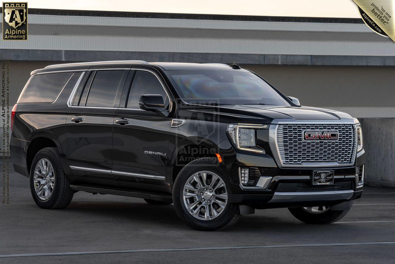 A black armored GMC Denali XL SUV from Alpine Armoring is parked on a rooftop.