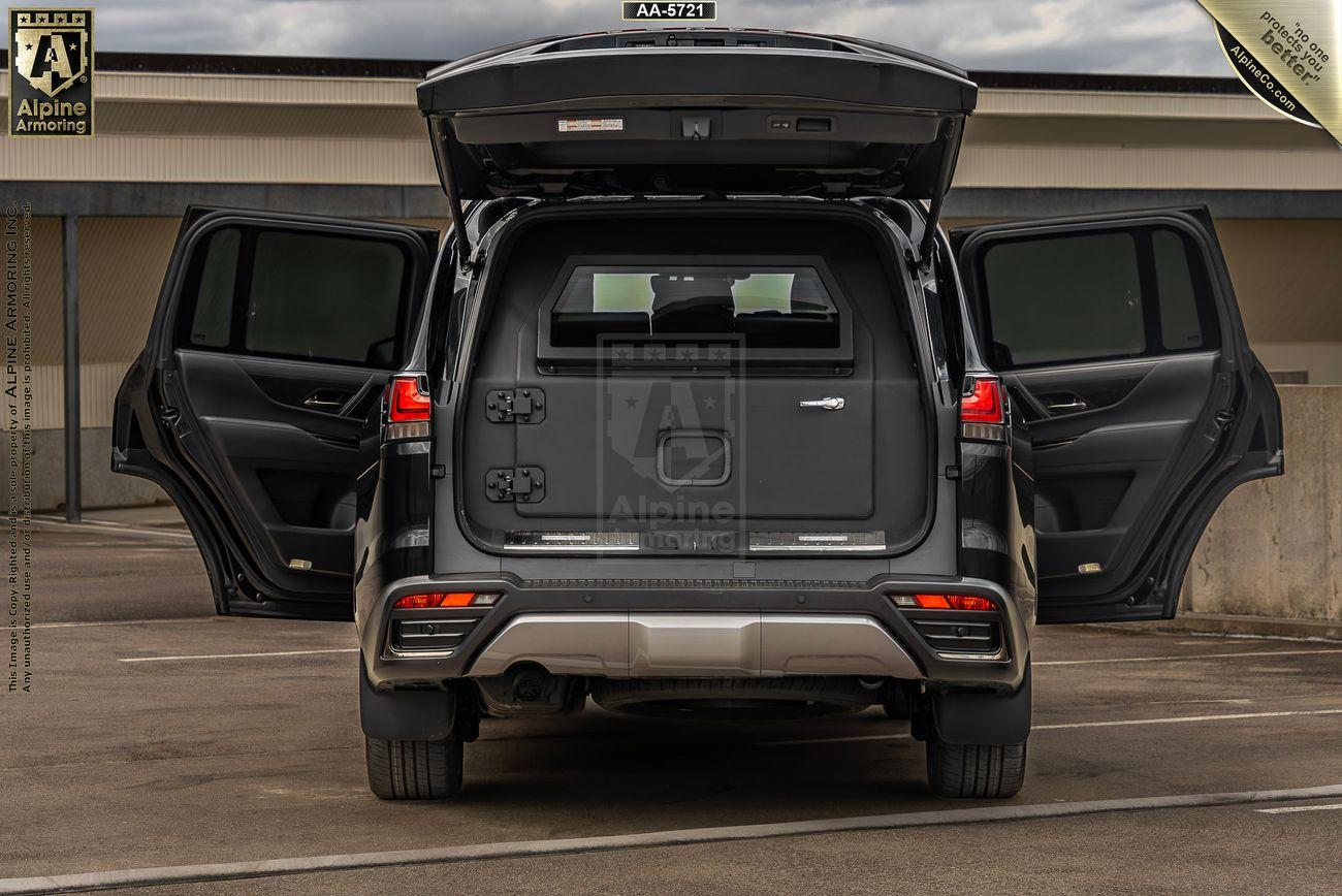 Rear view of a black Lexus LX600 Luxury SUV with all doors open, showcasing the interior and cargo space. The vehicle is parked in an outdoor setting under a cloudy sky.