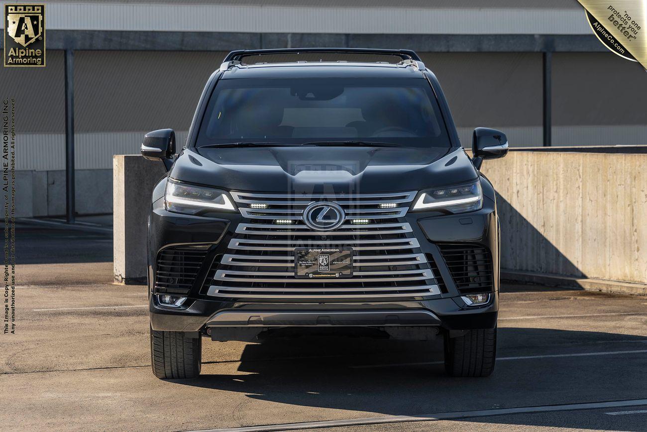 Front view of an armored Lexus LX600 Ultra Luxury showing its grill with a Lexus logo and Alpine Armoring license plate holder.