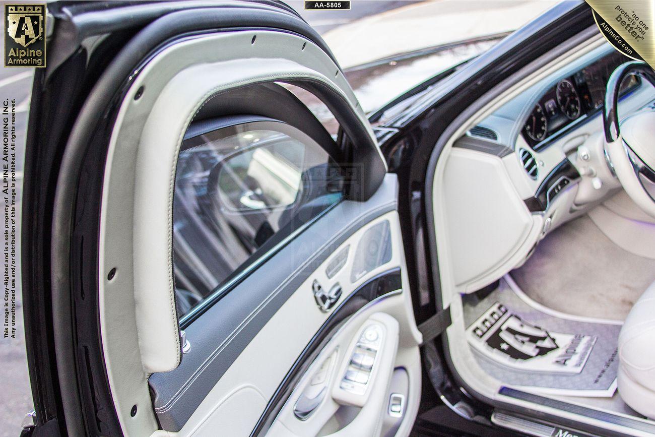 An open car door reveals a luxurious white interior with leather seats and detailed stitching. The car's dashboard, controls, and part of the passenger seat are visible.