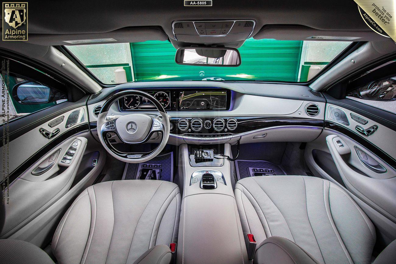  Mercedes-Benz 560 interior featuring a sleek steering wheel with the Mercedes-Benz logo, modern dashboard with multiple displays, and sophisticated design elements with beige leather seats and accents.