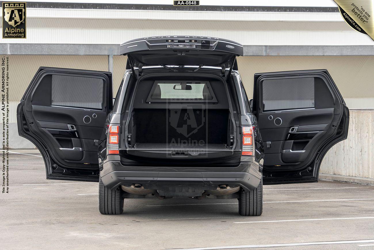 A black Range Rover Autobiography SUV with its rear doors and trunk open, parked in a multi-level garage.