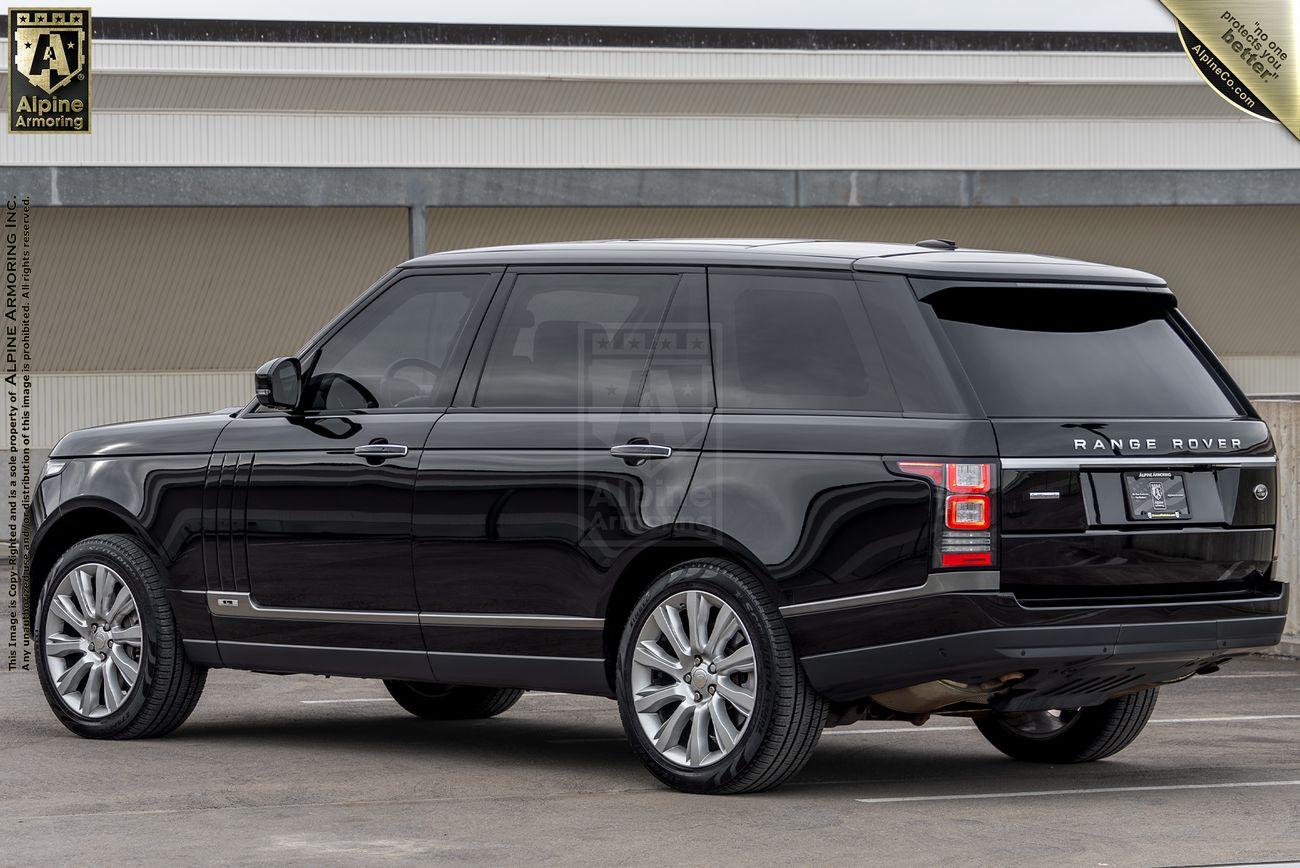 A black Range Rover Autobiography SUV is parked on a concrete surface with a building in the background.