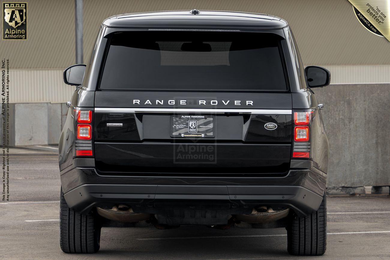 Rear view of a black Range Rover Autobiography with dark tinted windows, outfitted by Alpine Armoring Inc., parked in an outdoor lot.