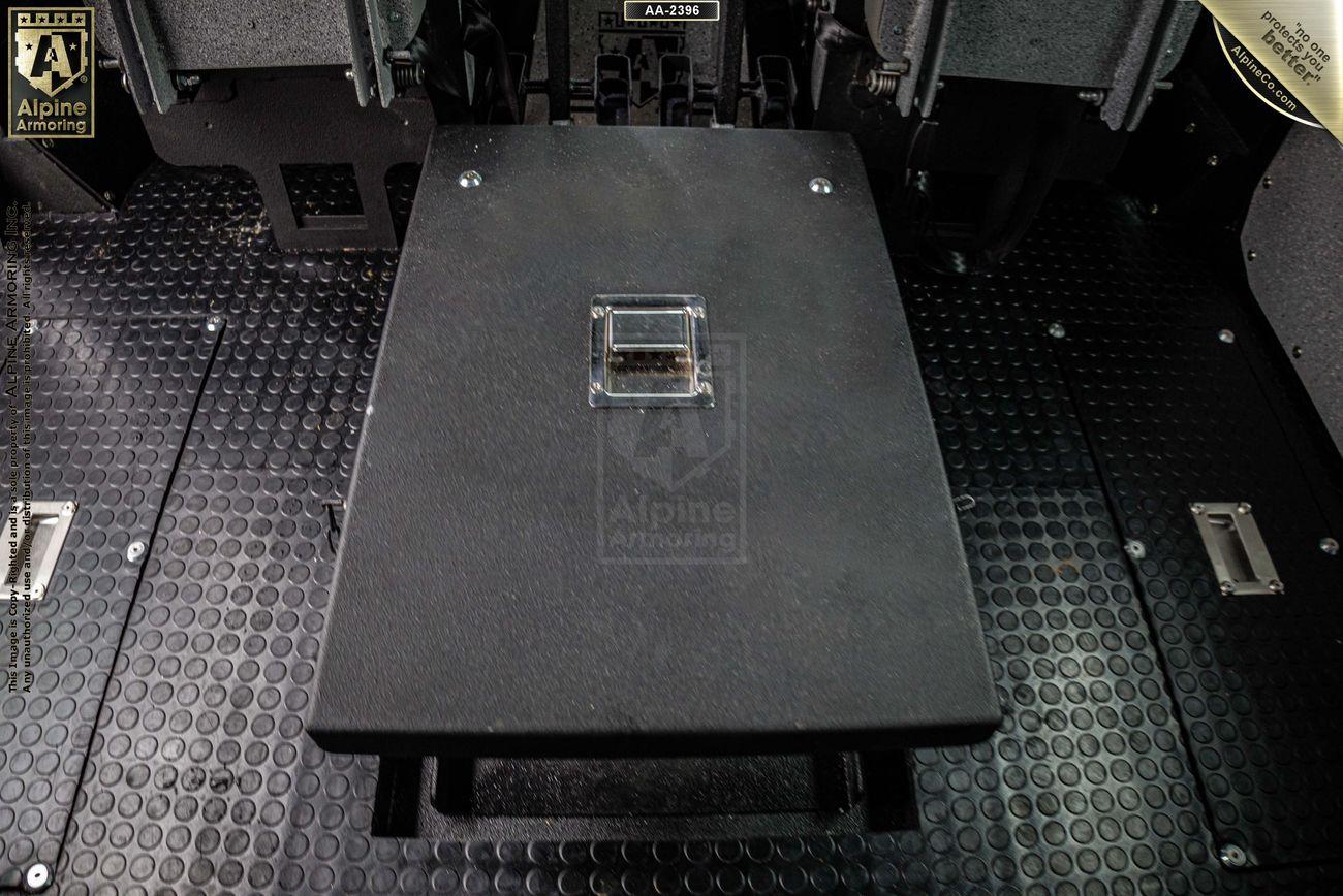 Interior of an armored Pit-Bull VX by Alpine Armoring, showcasing a central control panel on a textured metal floor.