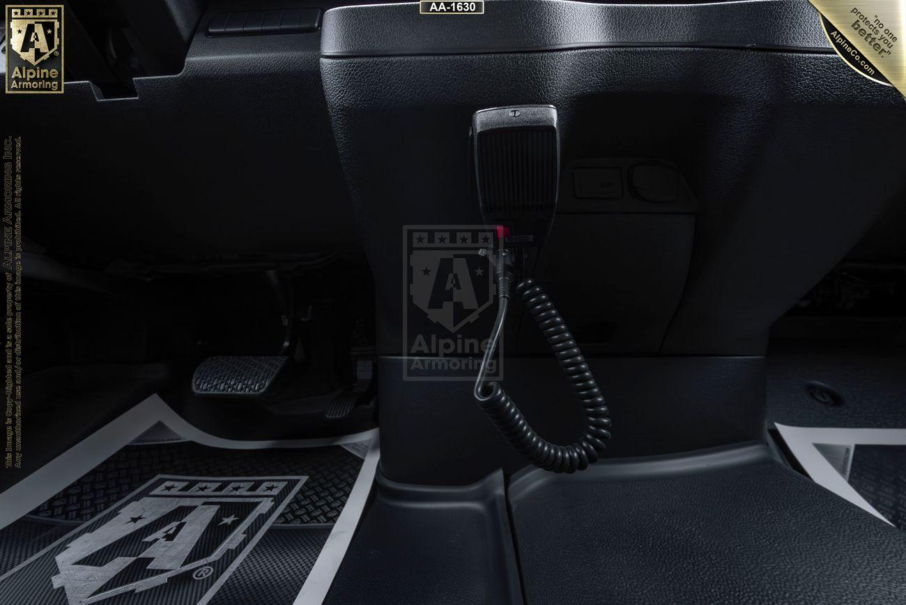 A view of a SWAT Van - Pointer's interior showing the dashboard, a coiled cable radio microphone, and branded floor mats.