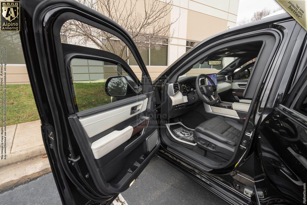 Open door of an armored Toyota Sequoia Capstone from Alpine Armoring showing luxurious black and white leather interior. 