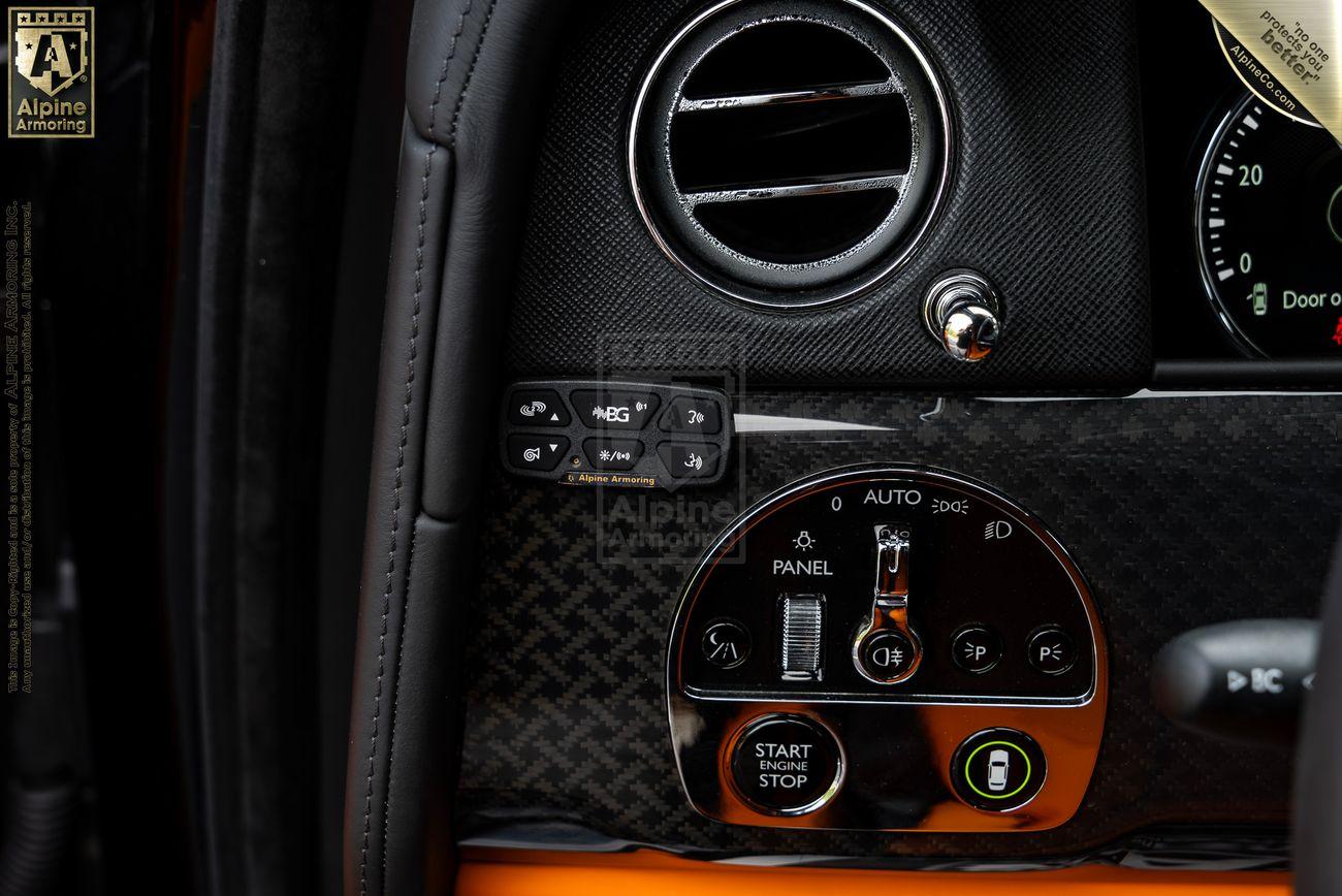 Close-up view of a Rolls-Royce Cullinan dashboard featuring various controls, including an air vent, start/stop button, and climate control settings.