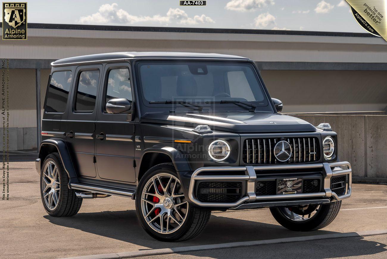 A black Mercedes-Benz G-Class SUV with silver trim and red brake calipers is parked on a rooftop with a cloudy sky in the background.