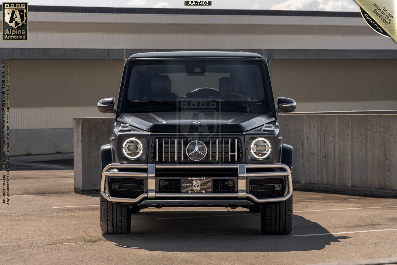 Front view of a black Mercedes-Benz G-Class SUV, from Alpine Armoring,  parked in an outdoor parking area.