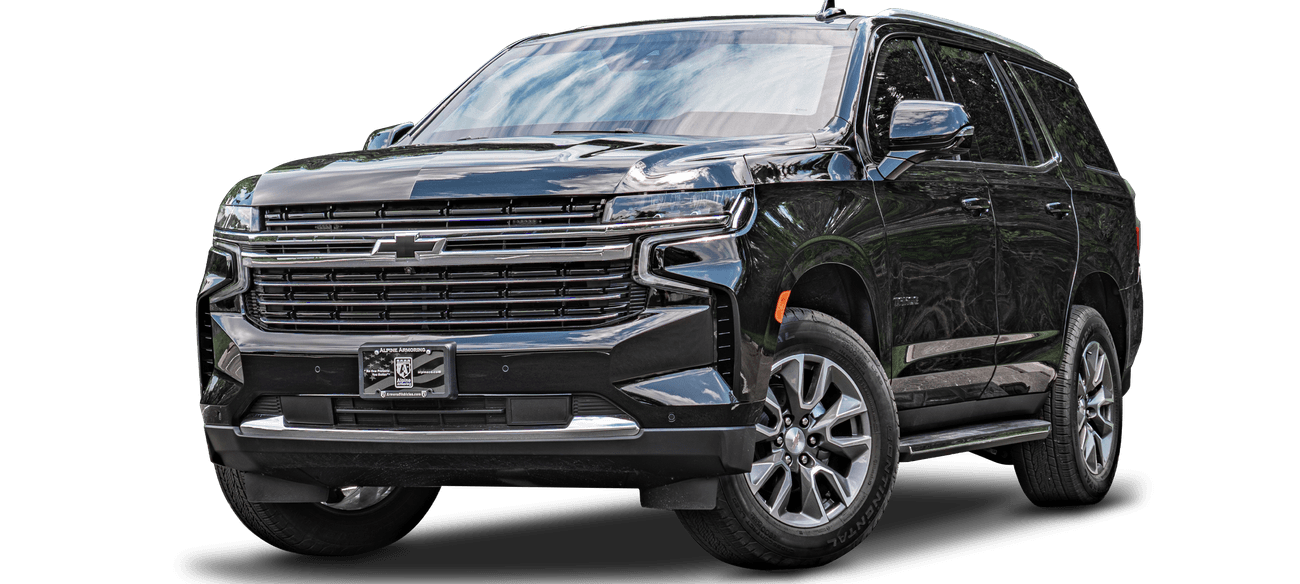 An armored black Chevrolet Tahoe SUV is parked, showing the front and right side view. It has a chrome grille, LED headlights, and alloy wheels.