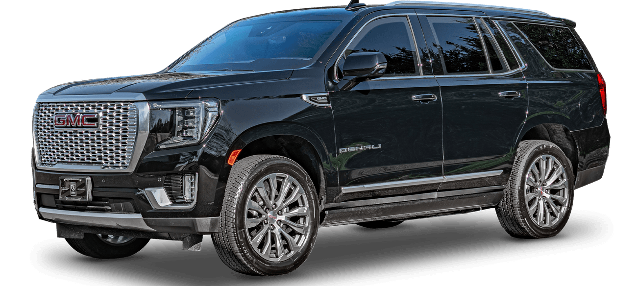 An armored black GMC Yukon Denali SUV, shown from a front-side angle, displaying its prominent grille, sleek design, and alloy wheels.