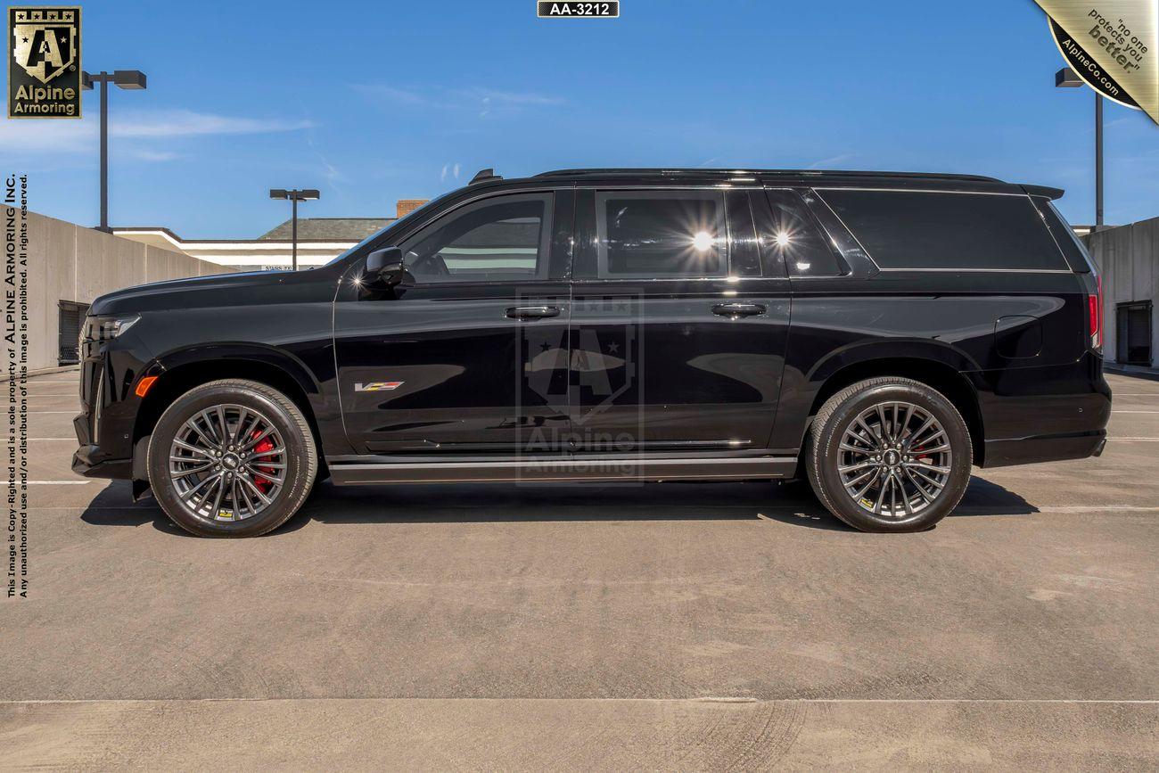 A black armored Cadillac Escalade ESV SUV is parked on a rooftop parking lot. The vehicle features a sleek design and appears to be in excellent condition.