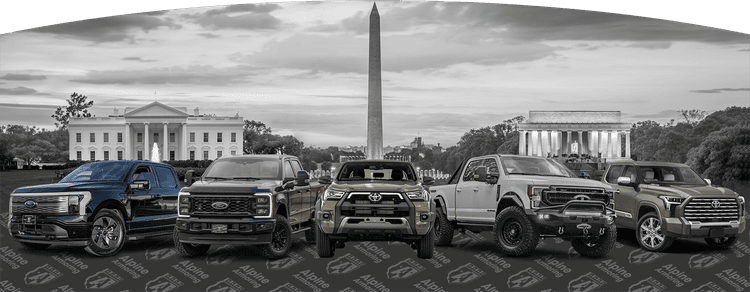 Five armored pickup trucks from Alpine Armoring, featuring brands like Ford and Toyota, displayed in front of Washington, D.C. landmarks.