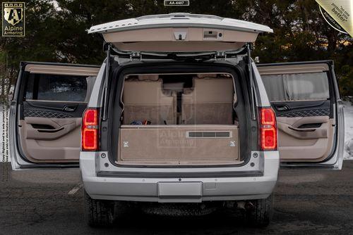 A white armored Chevrolet Suburban 3500HD LT VIP Limo with all doors open reveals a spacious, empty interior with beige lining.