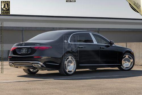 An armored Meredes Maybach viewed from the rear  in a parking area. The label "Alpine Armoring" is visible at the top of the image.