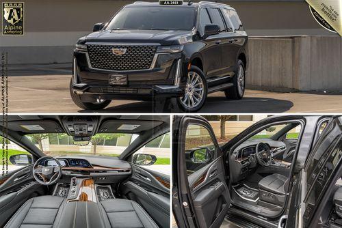 A luxury armored Cadillac Escalade ESV Premium LuxurySUV in black, shown in three views: front exterior, interior dashboard with steering wheel, and rear seating area with doors open. The vehicle is branded Alpine Armoring.