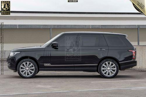 A black Range Rover Autobiography SUV is parked in an outdoor parking area. The vehicle has silver rims and tinted windows. The branding on the image indicates it's from Alpine Armoring.