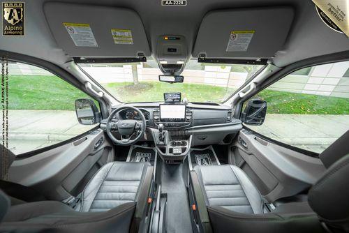 Interior view of a Ford Transit Pointer Van showing the dashboard, steering wheel, center console with a display screen, and front seats with black leather upholstery.