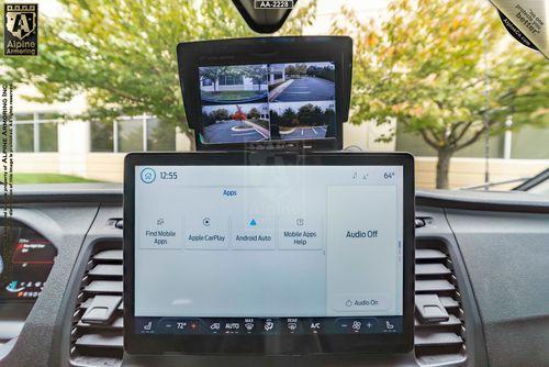 Close-up of a Ford Transit Pointer Van dashboard showing an infotainment screen with mobile apps options and a rearview camera display above it. The digital clock on the infotainment screen reads 12:55.