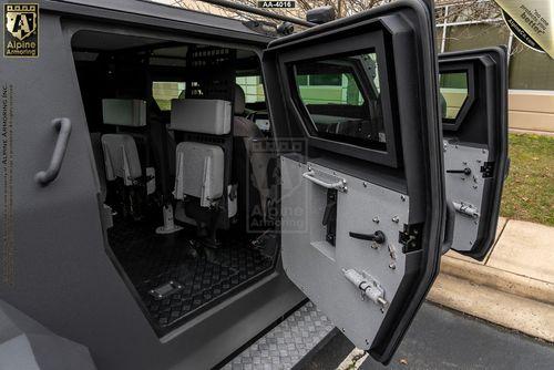 Interior of an armored Pit-Bull VXT with open side doors, revealing seating and secure locks.