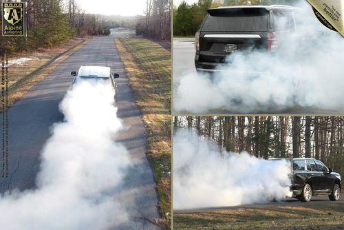 Three images of a black SUV performing a burnout, creating large clouds of smoke on a secluded road. The scenes are taken from different angles showing extensive tire smoke.